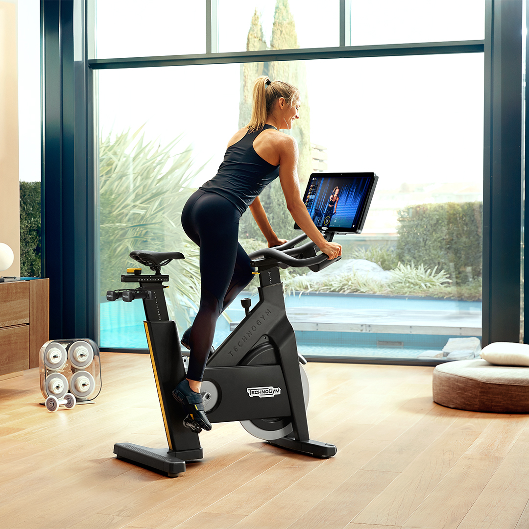 Woman riding a Technogym stationary bike. 