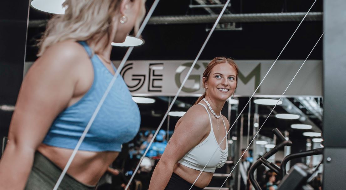 Two women using the ski erg machine during they Hyrox training programme. 